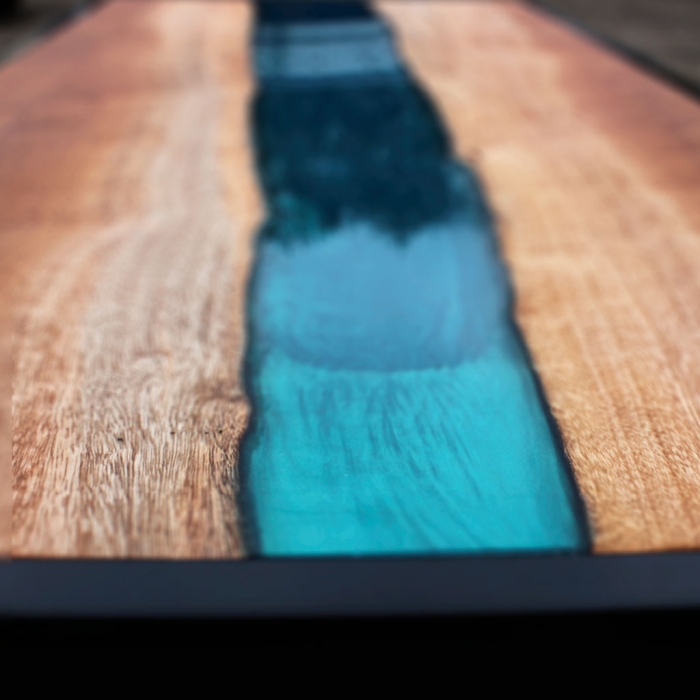 close-up van epoxy rivier in een mahonie tafel, gemaakt door Boemklaar Meubelmakers